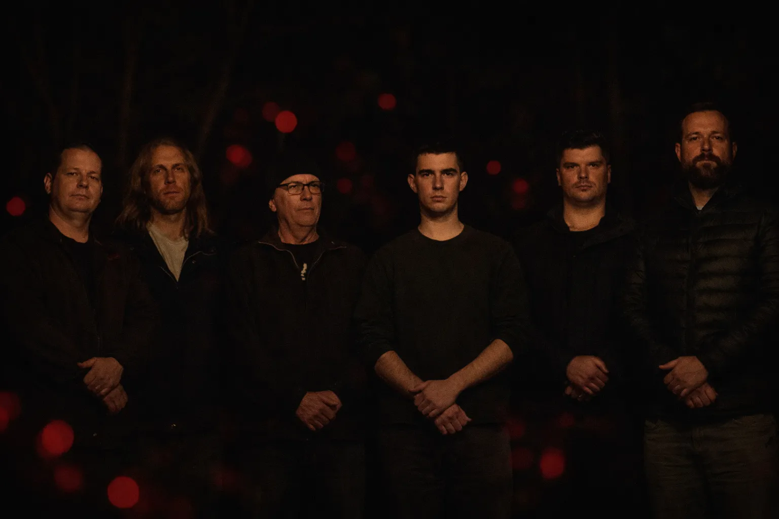 Six young men standing together at night in a powerful ceremonial moment