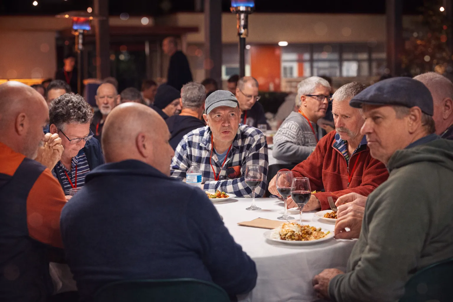 Men sharing a meal together at a long table, connecting over food