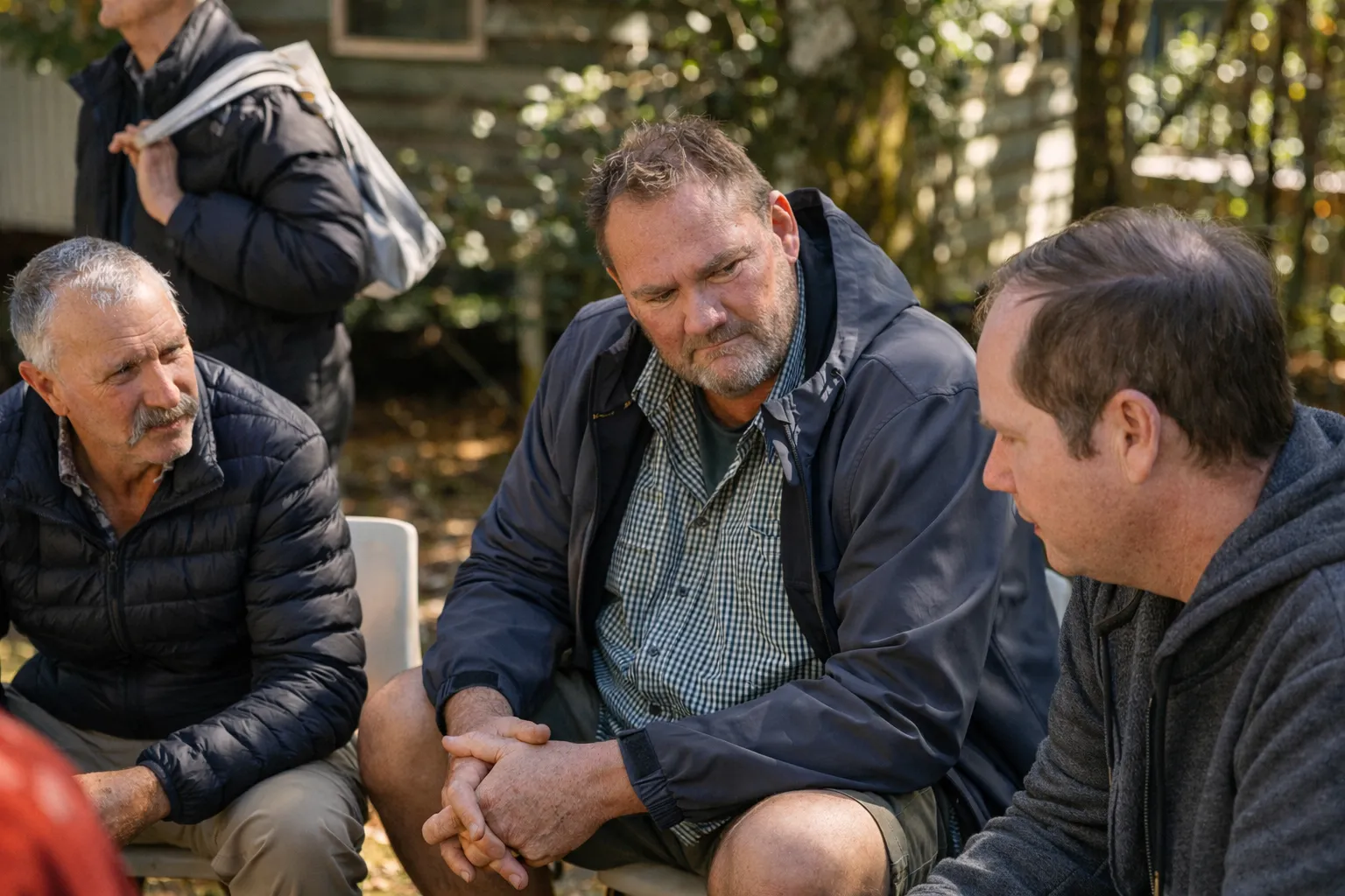 Men sitting in a circle, talking openly